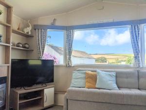 纽基Large 4 person Couples and Family Caravan in Newquay Bay Resort的带沙发和大窗户的客厅