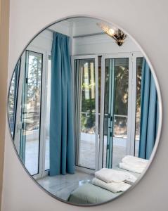 纳夫普利翁Unique, elegant Bourtzi View Villa的镜子反射着蓝色窗帘的房间