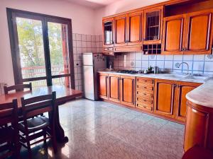 米斯泰尔比安科Relais Chiesa Madre - Rooms and Apartments的厨房配有木制橱柜和白色冰箱。