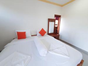 金塔马尼Batur Happy House的白色的床和橙色及白色的枕头