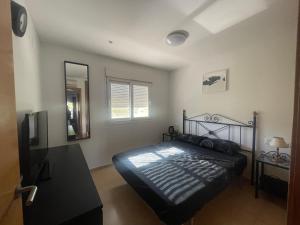 穆尔西亚Condado De Alhama Golf Resort 2 Bedroom Apartment Jardine 13的一间卧室配有一张黑色的床和镜子