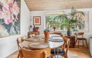 霍耶Nice Home In Hjer With House A Panoramic View的一间带木桌和椅子的用餐室