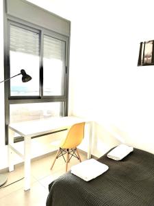 纳哈里亚Vacation Apartment by The Sea - Achziv的一间卧室配有书桌、一张床和一把椅子