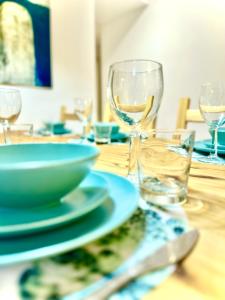 纳哈里亚Vacation Apartment by The Sea - Achziv的木桌,上面放着碗和玻璃杯