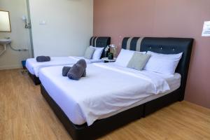 加央FAMILIA INN的配有2张床的带白色床单和枕头的客房