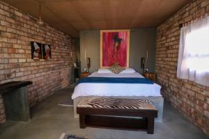 UisThe Desert House的一间卧室设有一张床和砖墙