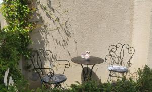 蒙彼利埃Belle dépendance, appartement cosy, tout confort的两张椅子和一张桌子,上面放着茶具