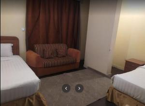 麦地那Zahret Al Madinah的配有一张床和一把椅子的酒店客房
