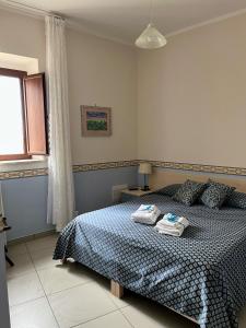 瓦洛-德拉卢卡尼亚La Casa al Piccolo Borgo的一间卧室配有一张床,上面有两条毛巾