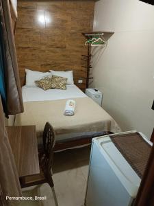 卡马拉吉贝Florcamará POUSADA的一间小卧室,配有一张床和一张桌子