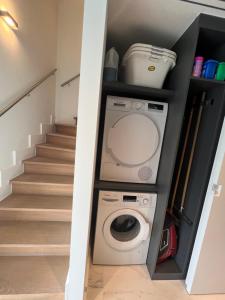 赫尔Luxury Business Accommodation Geel的洗衣房设有楼梯,配有洗衣机和烘干机