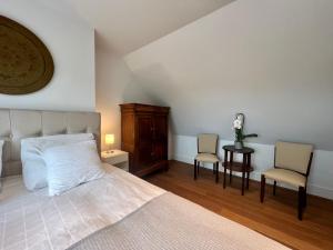 赫尔Luxury Business Accommodation Geel的一间卧室配有一张床和两把椅子