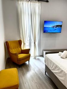 Ágios RókkosTravelers Luxury Suites, Studios & Apartments的一间卧室配有黄色椅子和一张床