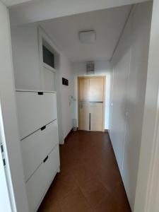 萨格勒布Apartment City的空的走廊,有白色的橱柜和门