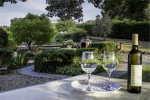因佩里亚La Quercia casa vacanza Imperia的桌子上放有一瓶葡萄酒和两杯酒