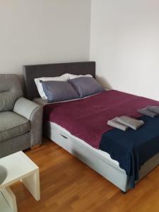 萨格勒布Apartment City的一张带两个枕头的床和一张沙发