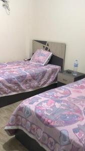 阿莱曼شاليه قرية قرطاج الساحل الشمالي的一间设有两张床和床头柜的房间