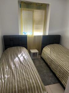 米迪克Charmant appart à 15 minutes de la plage et du centre ville M'DICQ, TETOUAN的一间卧室设有两张床和窗户。