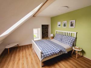 HartmaniceApartmány u Koláčků的一间卧室设有床铺和绿色的墙壁