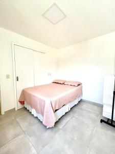 卡姆布库Apto 3 quartos no Wai Wai - Cumbuco-Ce的一间卧室配有一张带粉色毯子的床
