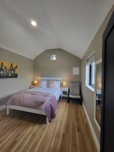 利斯坎诺Rose Meadow Lodge的一间卧室设有一张大床,铺有木地板