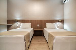 托莱多Bello Hotel的两张位于酒店客房的床,配有两张sidx sidx单人床