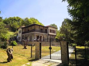 格雷韦纳Zenios Dionysos - Traditional villa的门前有狗的大门后面的房子