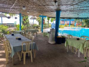 曼巴豪甘米金岛黄金日落海滩俱乐部度假村的一个带桌椅的庭院和一个游泳池