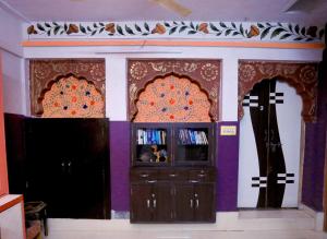焦特布尔Banaji Heritage Haveli的一间设有两个十字架的墙壁和一台电视的房间