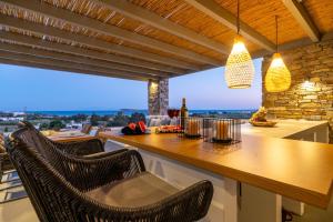 克里希阿克提Golden Bay luxury villas and suites的厨房设有配备椅子的酒吧,享有美景。