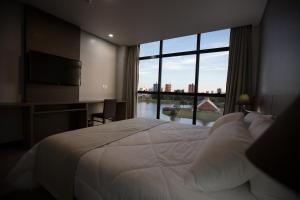 托莱多Bello Hotel的一间卧室设有一张大床和一个大窗户