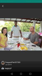 卡卢特勒Anura Home Stay的一群人坐在桌子旁吃着食物