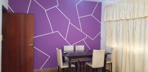 Leandro N. AlemBELLA CASA EN VILLA LIBERTAD的紫色的用餐室配有桌椅