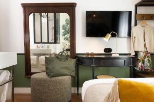 巴黎Avalon Cosy Hotel Paris的一间卧室配有一张床、一把椅子和镜子