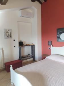 佩鲁贾Casale Mille e una Notte的卧室配有白色的床和红色的墙壁