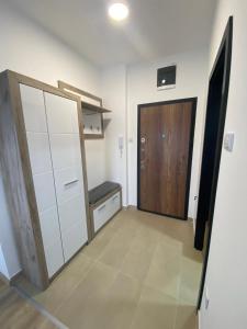 巴尼亚科维利亚查Apartman MI的一间设有衣柜和一扇带长凳的门的房间