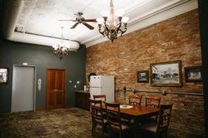 Bricktown Inn的一间设有桌子和砖墙的用餐室