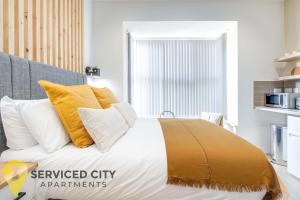 伯明翰SCA - Best Located Studio - CR1的一间卧室配有黄色和白色枕头的床