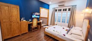 达拉万度Athirige Private Villa Dharavandhoo的一间卧室配有一张床、一张书桌和一台电视