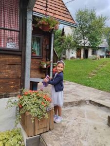 莫克拉戈拉Kuća za odmor Kalina的站在花盒旁的小女孩