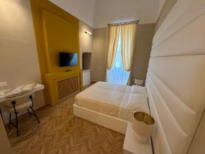 比谢列Palazzo Bonomi的一间卧室配有一张床、一张书桌和一台电视