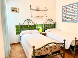 卡拉莫若尔Villa Menorquina en playa的绿白色客房内的两张床