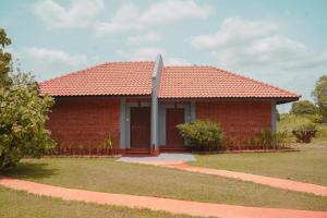 锡吉里亚Foresta Resort Sigiriya的红砖房子,有红色屋顶