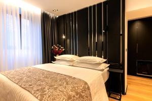 扎达尔City Premium Heritage的一间卧室配有一张带黑色墙壁和白色枕头的床。