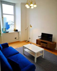 达农The Snug的客厅配有蓝色的沙发和茶几