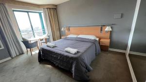 门多萨Apartments Millennium InnMendoza的一间卧室配有一张床、一张桌子和一个窗户。