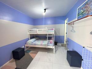 伊瓜苏Hostel Quintal de Casa的客房设有双层床和蓝色的墙壁。