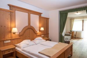 法尔泽斯福肯酒店的一间卧室配有一张大床和木制床头板