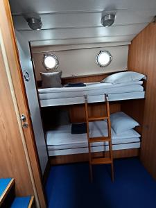 BrovinjeTraditional 2 bedroom houseboat Nova Natalina的小房间设有两张双层床和椅子