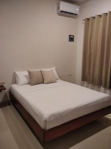 巴卡拉尔Apartamento的一张带白色床单和枕头的床